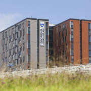 View of exterior with orange wall. - View apartment, architecture, building, city, condominium, corporate headquarters, facade, residential area, shipping container, tower block, urban area