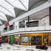 View of interior of mall. - View of building, mixed use, outlet store, retail, shopping mall, white