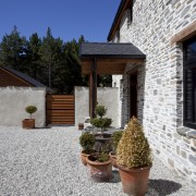 View of entrance with potted plants and stone cottage, estate, facade, home, house, property, real estate, gray