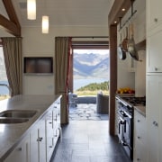 View of kitchen with dark flooring, light toned cabinetry, ceiling, countertop, cuisine classique, floor, flooring, home, house, interior design, kitchen, real estate, room, gray