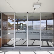 View of doorway to school. - View of architecture, door, glass, house, real estate, window, gray