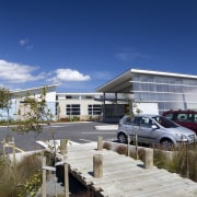 View of bridge over garden to parking lot. architecture, building, home, house, property, real estate, residential area, sky, blue, gray