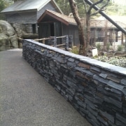 View of stone wall. - View of stone brickwork, fence, house, outdoor structure, property, real estate, stone wall, walkway, wall, gray, black