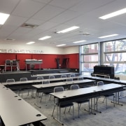 View of classroom with dark furniture and red cafeteria, classroom, conference hall, institution, interior design, room, table, gray