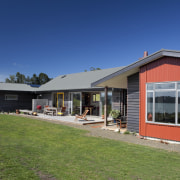 View of exterior with red wall and patio cottage, estate, facade, farmhouse, home, house, property, real estate, residential area, roof, siding, sky, window, blue