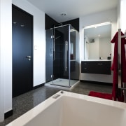 Bathroom with contemporary white tub, black door and bathroom, interior design, real estate, room, gray, white