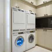 Laundry with cream cupboards and stacked dryer and clothes dryer, home appliance, laundry, laundry room, major appliance, product design, room, washing machine, gray