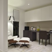 Desk area with cream cupboards and brown chair. floor, flooring, interior design, living room, room, gray