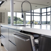 View of open dishwasher with dark cupboards and architecture, countertop, floor, glass, handrail, interior design, kitchen, gray