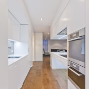 A view of a kitchen designed by Celia architecture, ceiling, countertop, daylighting, floor, flooring, hardwood, interior design, kitchen, laminate flooring, real estate, wood, wood flooring, gray