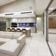 Lounge and kitchen area with cream couches and ceiling, floor, flooring, interior design, lobby, real estate, gray