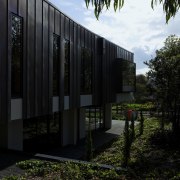 Exterior of house and garden. - Exterior of architecture, building, facade, grass, home, house, real estate, reflection, sky, sunlight, tree, black