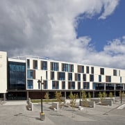 Exterior with white and glass wall. - Exterior architecture, building, commercial building, corporate headquarters, facade, mixed use, sky, gray