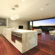 Kitchen with marble island top and wooden flooring. architecture, ceiling, countertop, floor, flooring, hardwood, interior design, kitchen, real estate, wood flooring, orange, red