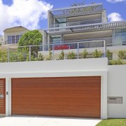 Exterior of house with wooden garage door. - architecture, building, elevation, estate, facade, home, house, official residence, property, real estate, residential area, white, gray