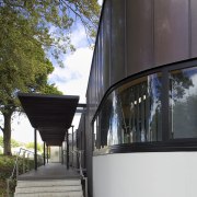 Exterior with curved windows. - Exterior with curved architecture, building, facade, house, reflection, tree, black, gray