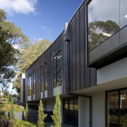 Exterior with brown walls and plants next to architecture, building, corporate headquarters, facade, home, house, mixed use, real estate, residential area, sky, black