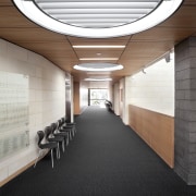Interior with round light feature and grey carpeting. architecture, ceiling, daylighting, floor, interior design, lobby, black, white