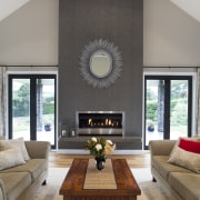 lounge with fireplace and circular mirror, tw couches ceiling, hearth, home, house, interior design, living room, room, table, gray
