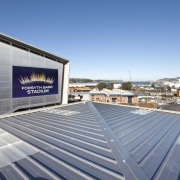 View of grey building and grey roof. - architecture, building, corporate headquarters, daylighting, daytime, energy, facade, real estate, roof, sky, structure, teal, gray