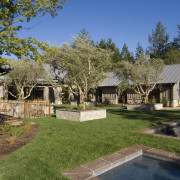 Rustic house modelled on French barn. Interiors feature backyard, cottage, estate, farmhouse, home, house, landscape, property, real estate, residential area, tree, villa, yard, brown