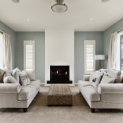 fireplace between two couches, green and white walls couch, floor, furniture, home, interior design, living room, loveseat, property, real estate, room, window, gray