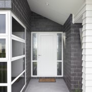 Exterior of single-storey house, dark stone cladding, and architecture, door, facade, home, house, real estate, siding, window, gray