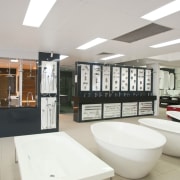 shop floor showing range of bathtubs, different angle interior design, gray