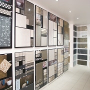 swatches of wallpaper, tiles, paint in showroom - bookcase, cabinetry, floor, furniture, interior design, shelf, shelving, white