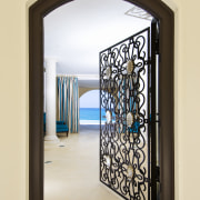 This home was designed by Geoffrey Bradfield. Here door, glass, iron, window, orange