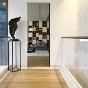 The shelving units featured in this family room floor, flooring, glass, handrail, hardwood, home, interior design, laminate flooring, wall, window, wood, wood flooring, white