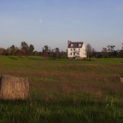 This home was built by Tom Glass of cloud, farm, farmhouse, field, grass, grass family, grassland, hill, house, land lot, meadow, pasture, plain, prairie, rural area, sky, tree, village, brown