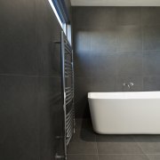 Bathroom remodel featuring gray Basalt tiles, free-standing tub architecture, bathroom, floor, flooring, interior design, plumbing fixture, product design, property, room, tile, black, gray