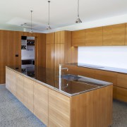 Expansive kitchen with stainless steel countertops and wood cabinetry, countertop, furniture, interior design, kitchen, plywood, product design, wood, white