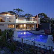 This home was designed and built by Graeme architecture, backyard, elevation, estate, facade, home, house, lighting, property, real estate, residential area, resort, swimming pool, villa, blue, black