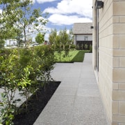 This 'Life at Home' home features paving from architecture, courtyard, driveway, estate, garden, grass, home, house, landscaping, neighbourhood, plant, property, real estate, residential area, road surface, sky, tree, walkway, yard, gray