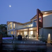 This home was designed and built by Graeme architecture, building, estate, evening, facade, home, house, landscape lighting, lighting, property, real estate, residential area, sky, villa, window, blue