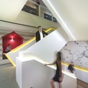 In the new Lion office fit-out in Sydney, architecture, ceiling, daylighting, design, floor, flooring, furniture, house, interior design, lighting, product design, room, stairs, table, white, gray