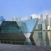 The Louis Vuitton Island Maison in Singapore appears architecture, building, city, cityscape, commercial building, condominium, corporate headquarters, daytime, downtown, fixed link, headquarters, landmark, metropolis, metropolitan area, mixed use, reflection, sky, skyline, skyscraper, tower block, urban area, water, teal, gray