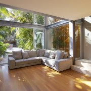 A glazed, three-storey atrium fills this home with architecture, ceiling, daylighting, estate, floor, hardwood, home, house, interior design, living room, property, real estate, window, wood, wood flooring, brown