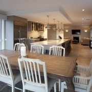 A new entertainers kitchen connects existing and remodelled dining room, estate, floor, flooring, home, interior design, living room, property, real estate, room, table, gray