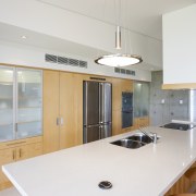 The kitchen features contrasting warm wood surfaces and cabinetry, countertop, cuisine classique, interior design, kitchen, real estate, room, white, gray
