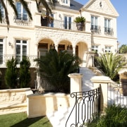 The exterior of this new home evokes traditional arecales, backyard, building, courtyard, estate, facade, hacienda, historic house, home, house, mansion, outdoor structure, palm tree, property, real estate, residential area, villa, white, brown