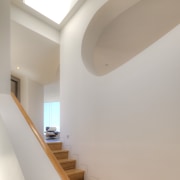 The distinctive shape of a cutout in the architecture, ceiling, daylighting, handrail, home, house, interior design, light, product design, property, stairs, wall, gray