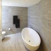 In keeping with the simple material palette in architecture, bathroom, ceiling, floor, flooring, interior design, plumbing fixture, product design, room, sink, tap, tile, wall, wood, wood flooring, gray