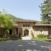 Decorative front door with limestone surround on Mediterranean-style courtyard, estate, facade, garden, hacienda, home, house, landscape, landscaping, mansion, official residence, property, real estate, tree, villa, brown