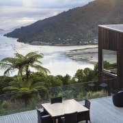 A material palette of timber and stone ensures estate, home, house, property, real estate, resort, sea, vacation, villa, gray, black