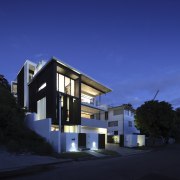 This modern four-level house steps down a steep apartment, architecture, building, condominium, corporate headquarters, facade, home, house, mixed use, property, real estate, residential area, sky, blue, black