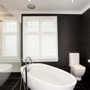 A freestanding tub with floor-mounted tub filler feature bathroom, floor, interior design, plumbing fixture, product design, room, tap, tile, window, white, black