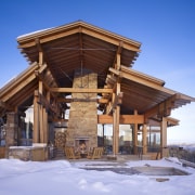 An exoskeleton of chunky wood beams and extended cottage, home, house, hut, log cabin, outdoor structure, property, real estate, roof, shed, siding, snow, winter, wood, teal